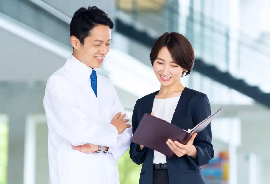 書類を見て微笑む男女